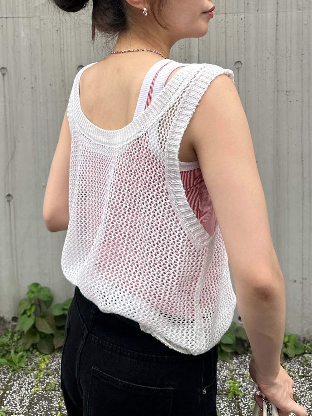 ブラック系のサンダル、ホワイト系のショルダーバッグ、ブラック系のデニムパンツを着用したレディースの夏コーディネートの3枚目の写真