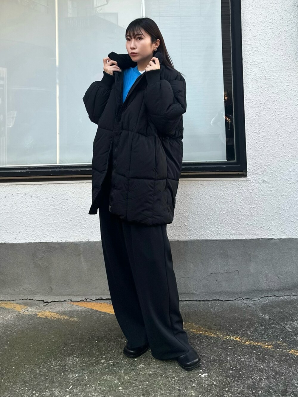 ブラック系のその他パンツ、ブラック系のダウンジャケット/コート、ブルー系のカーディガン/ボレロを着用したレディースの冬コーディネートの2枚目の写真
