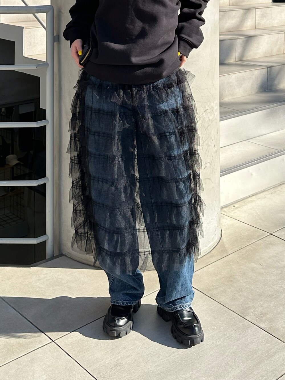 ブラック系のタンクトップ、ブラック系のローファー、シルバー系のピアス（両耳用）を着用したレディースの春コーディネートの3枚目の写真