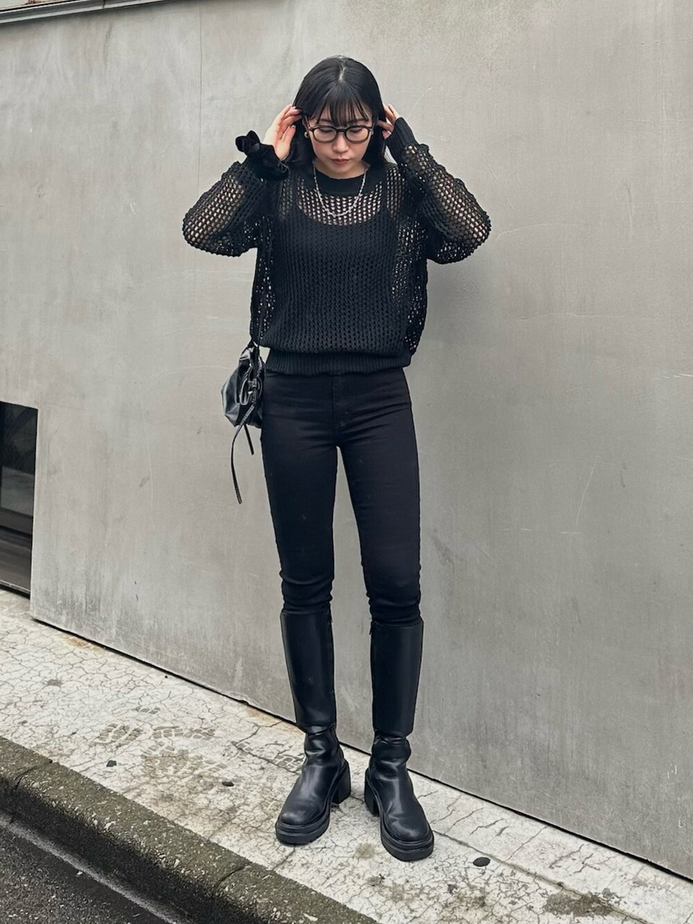 ブラック系のニット/セーター、ブラック系のブーツ、ブラック系のパンツを着用したレディースの春コーディネートの2枚目の写真