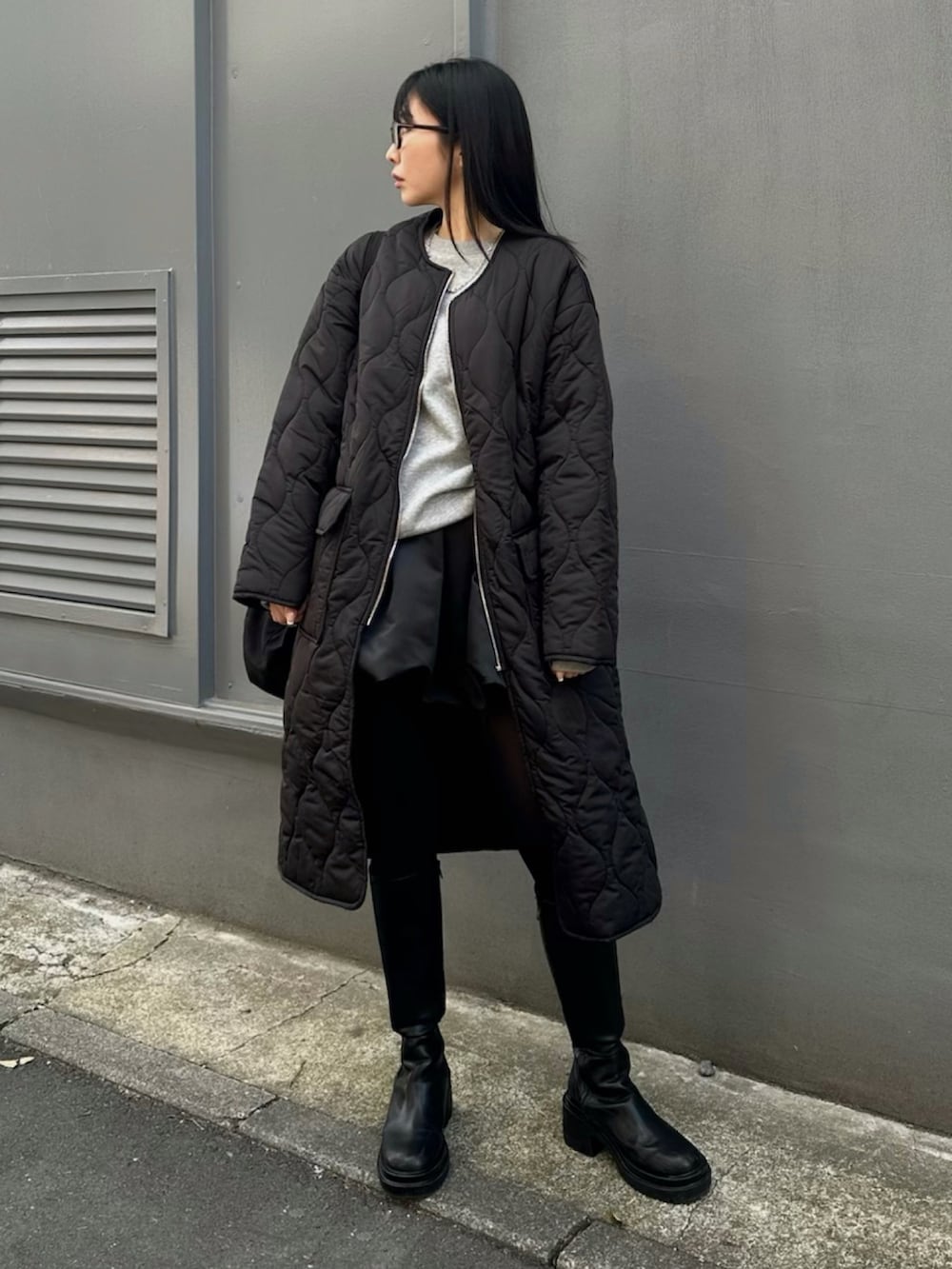 ブラック系のダウンジャケット/コート、ブラック系のブーツ、ブラック系のスカートを着用したレディースの冬コーディネートの2枚目の写真