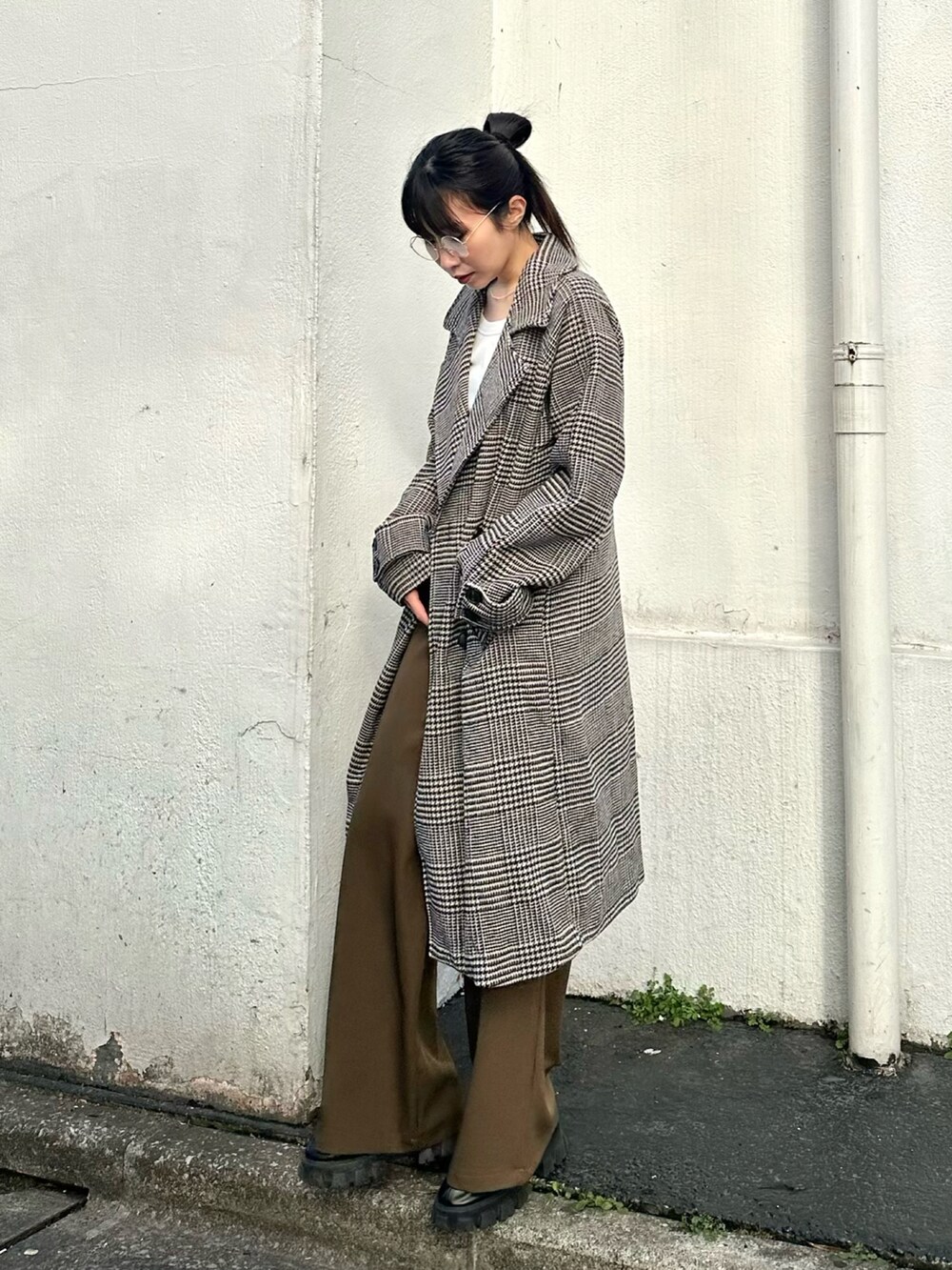 ブラウン系のスラックス、ブラウン系のチェスターコート、ホワイト系のTシャツ/カットソーを着用したレディースの冬コーディネートの2枚目の写真