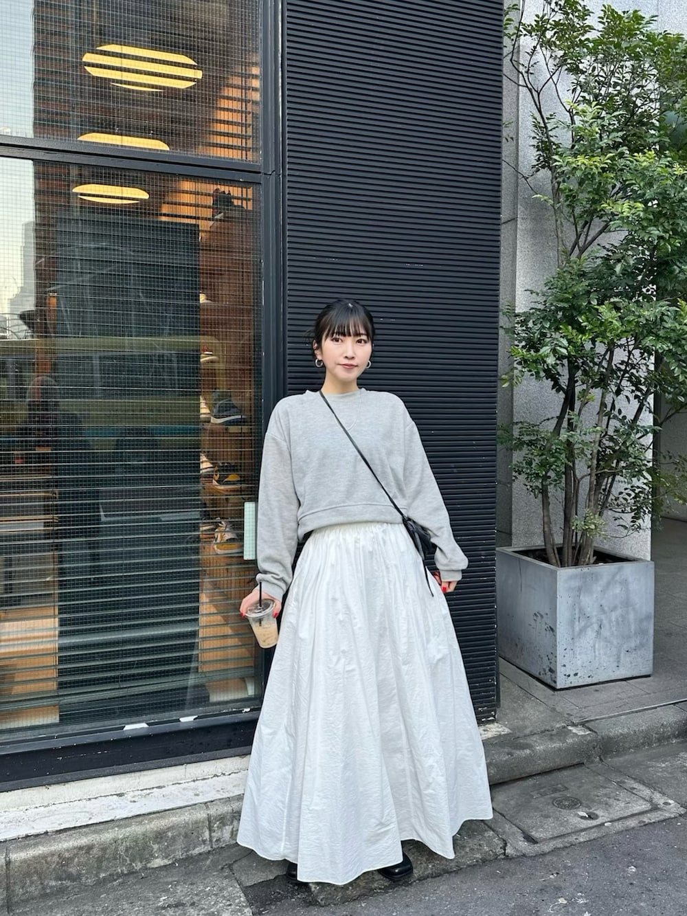 ホワイト系のスカート、グレー系のTシャツ/カットソー、ブラック系のブーツを着用したレディースの冬コーディネートの2枚目の写真