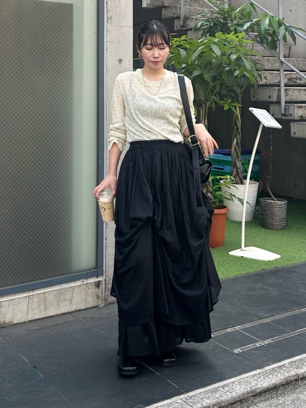 ブラック系のブーツ、グリーン系のTシャツ/カットソー、ブラック系のスカートを着用したレディースの秋コーディネートの2枚目の写真