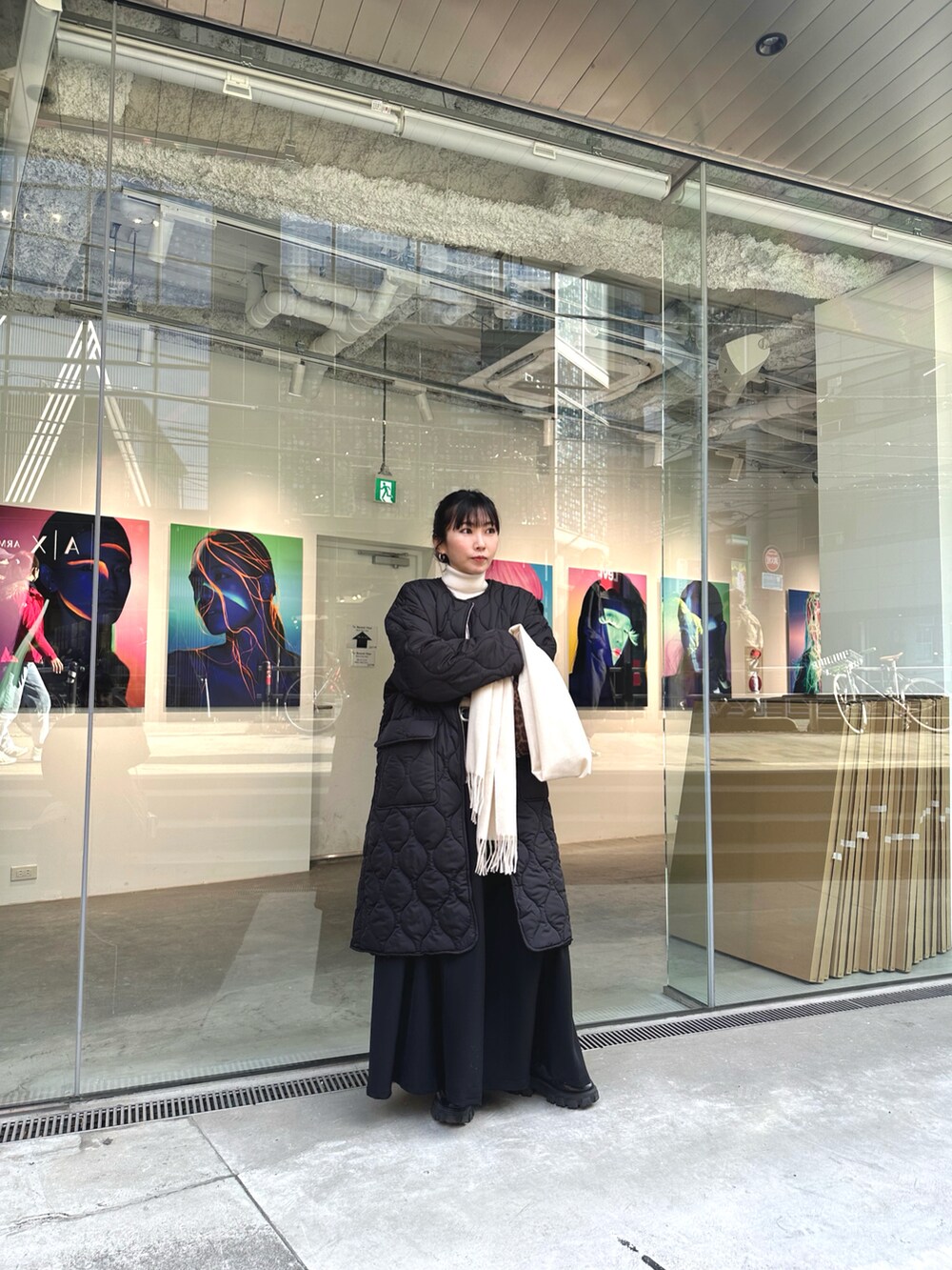 ブラック系のダウンジャケット/コート、ホワイト系のニット/セーター、ブラック系のスカートを着用したレディースの冬コーディネートの3枚目の写真