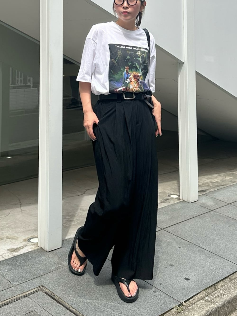 ブラック系のサンダル、ブラック系のスラックス、ブラック系のベルトを着用したレディースの夏コーディネートの2枚目の写真