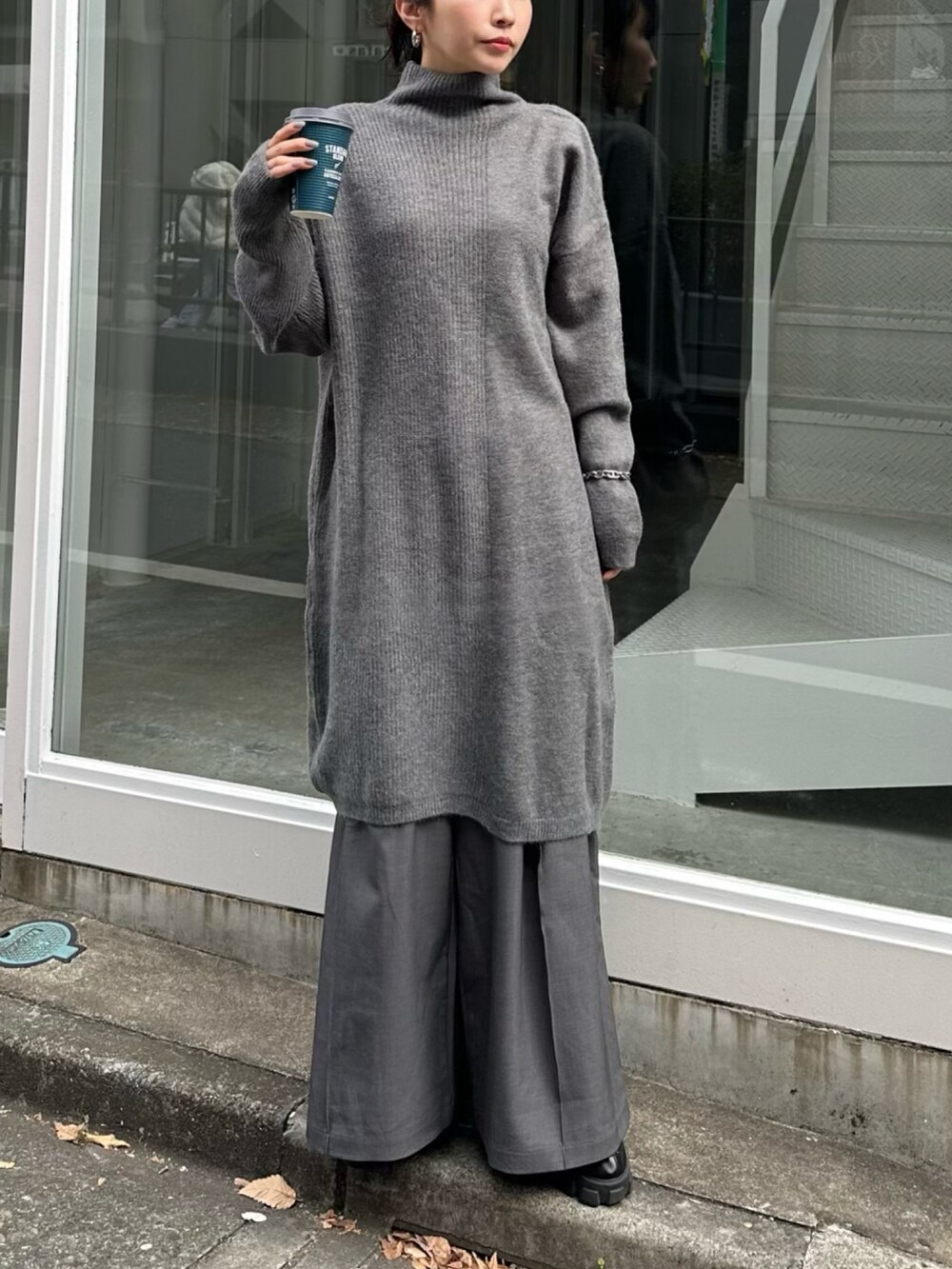 グレー系のワンピース、グレー系のスラックスを着用したレディースの冬コーディネートの2枚目の写真