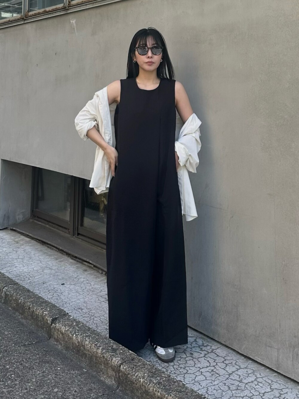 ブラック系のつなぎ/オールインワン、ホワイト系のシャツ/ブラウス、ホワイト系のスニーカーを着用したレディースの春コーディネートの2枚目の写真