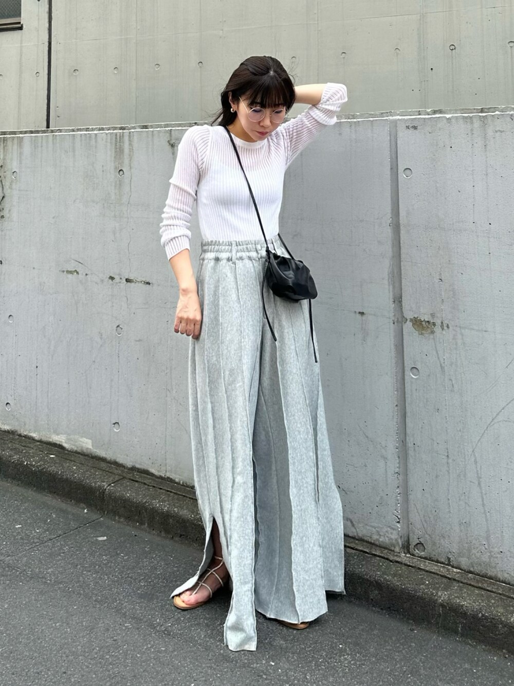 ホワイト系のニット/セーター、グレー系のスウェットパンツ、ベージュ系のサンダルを着用したレディースの春コーディネートの2枚目の写真