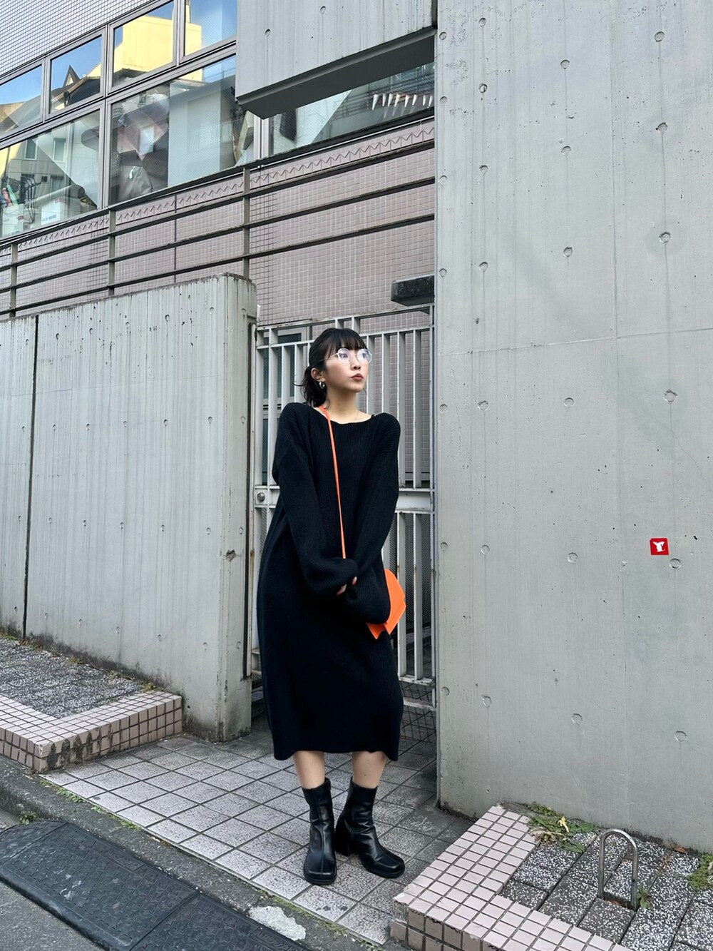 ブラック系のワンピース、ブラック系のブーツを着用したレディースの冬コーディネートの2枚目の写真