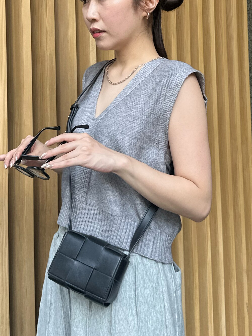 グレー系のスウェットパンツ、グレー系のベスト、シルバー系のネックレスを着用したレディースの夏コーディネートの3枚目の写真