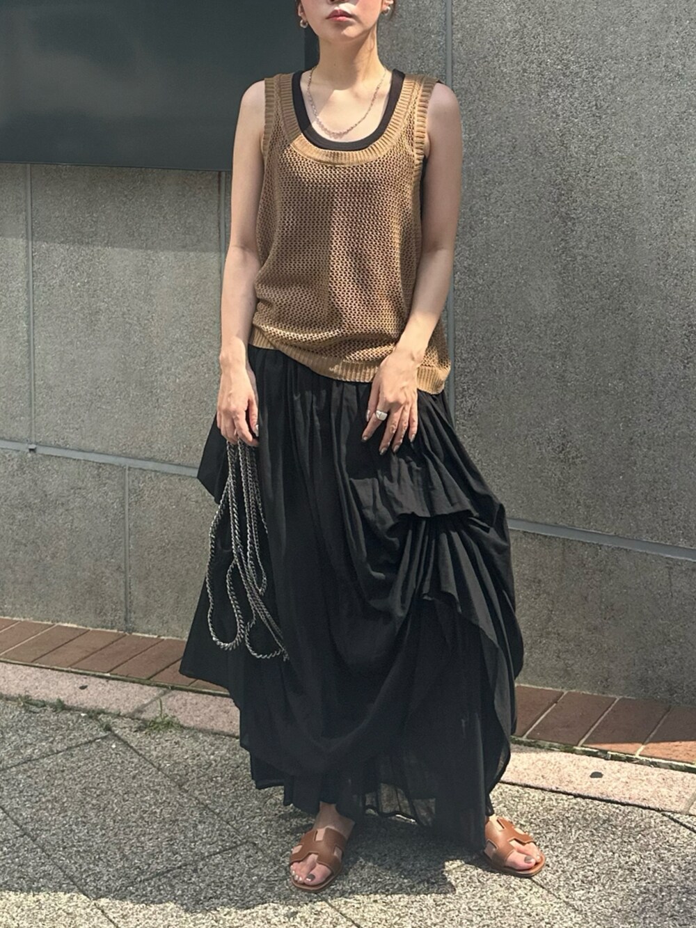 ブラウン系のタンクトップ、ブラック系のスカート、ブラウン系のサンダルを着用したレディースの夏コーディネートの2枚目の写真