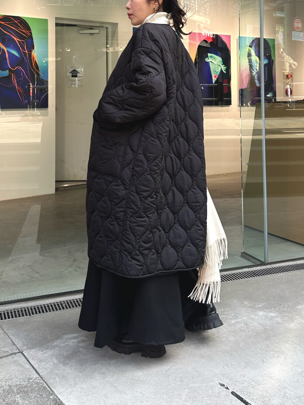 ブラック系のダウンジャケット/コート、ホワイト系のニット/セーター、ブラック系のスカートを着用したレディースの冬コーディネートの4枚目の写真