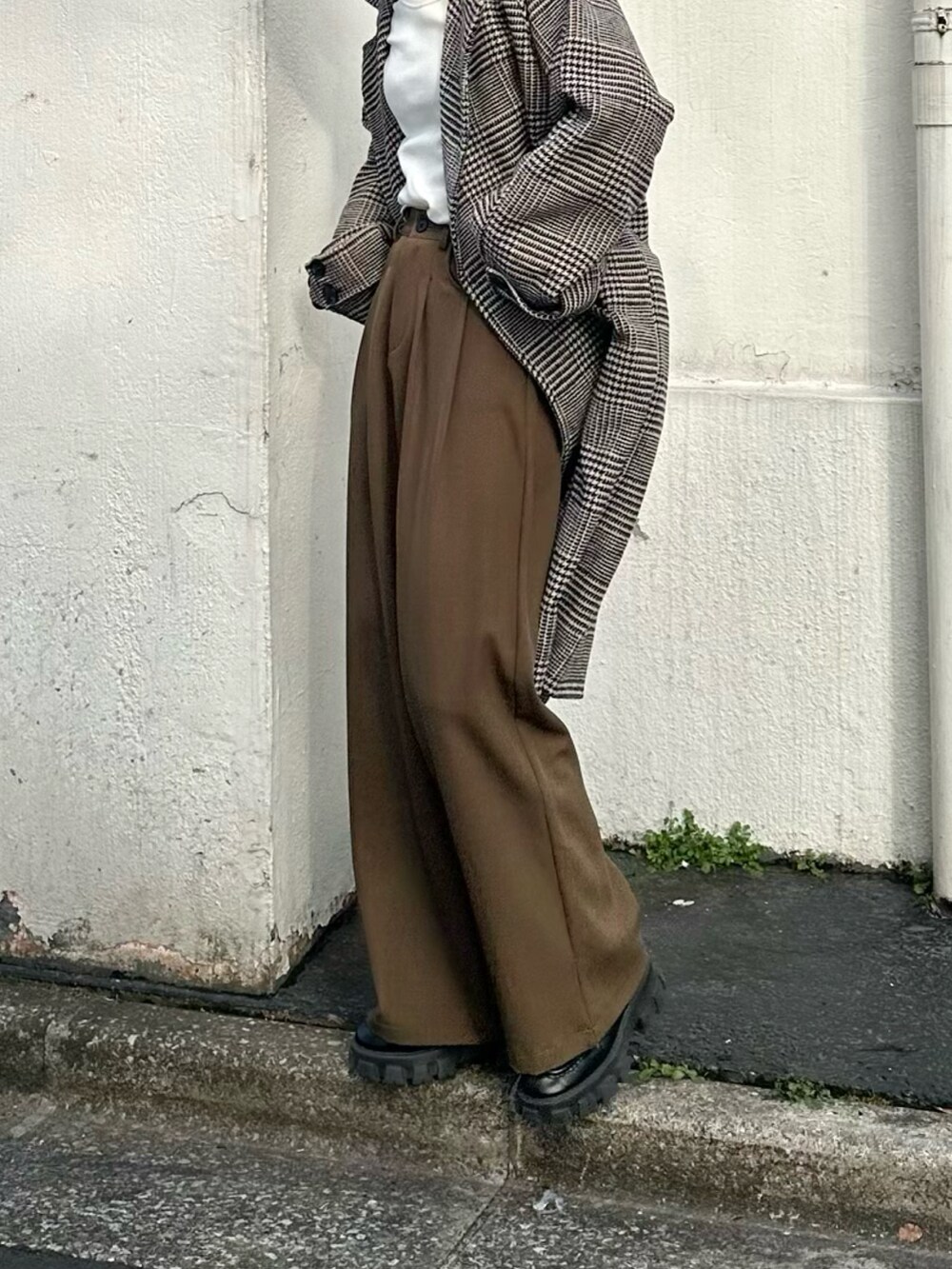 ブラウン系のスラックス、ブラウン系のチェスターコート、ホワイト系のTシャツ/カットソーを着用したレディースの冬コーディネートの3枚目の写真