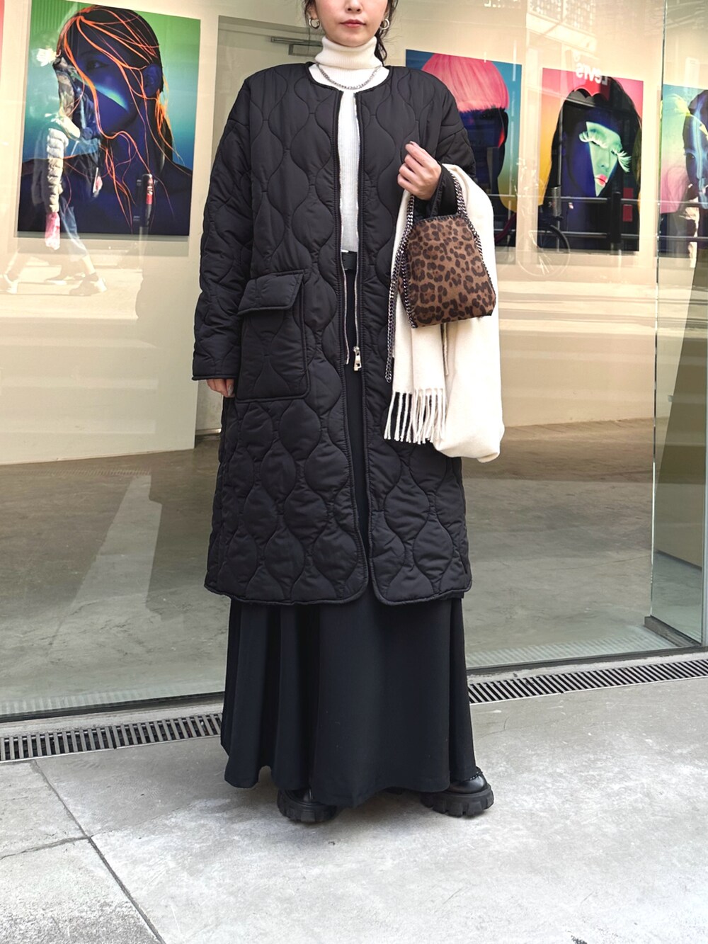 ブラック系のダウンジャケット/コート、ホワイト系のニット/セーター、ブラック系のスカートを着用したレディースの冬コーディネートの2枚目の写真