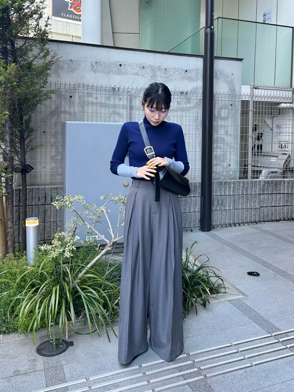 グレー系のスラックス、ブルー系のニット/セーターを着用したレディースの春コーディネートの2枚目の写真