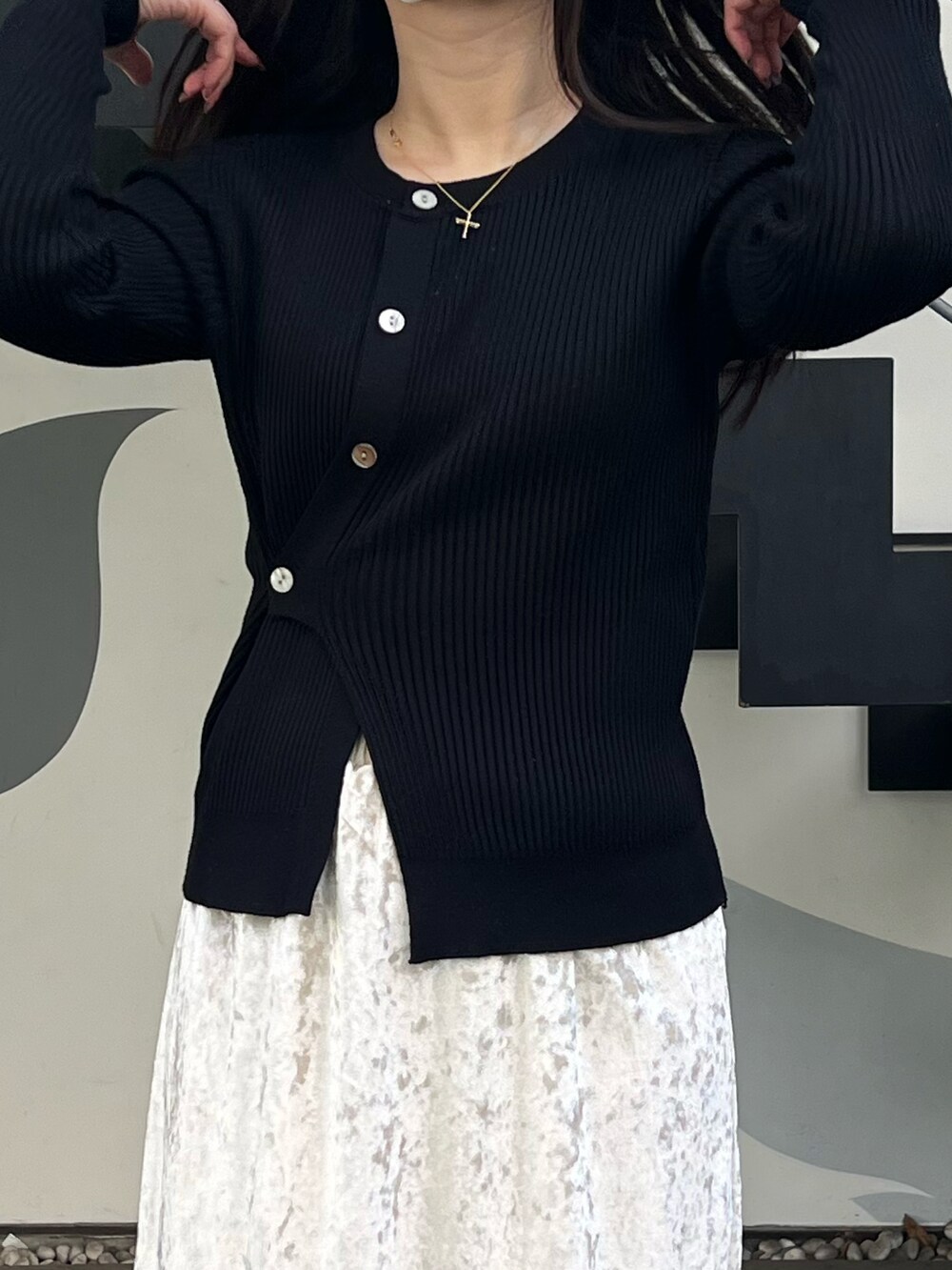 ブラック系のニット/セーター、ベージュ系のスカートを着用したレディースの冬コーディネートの2枚目の写真