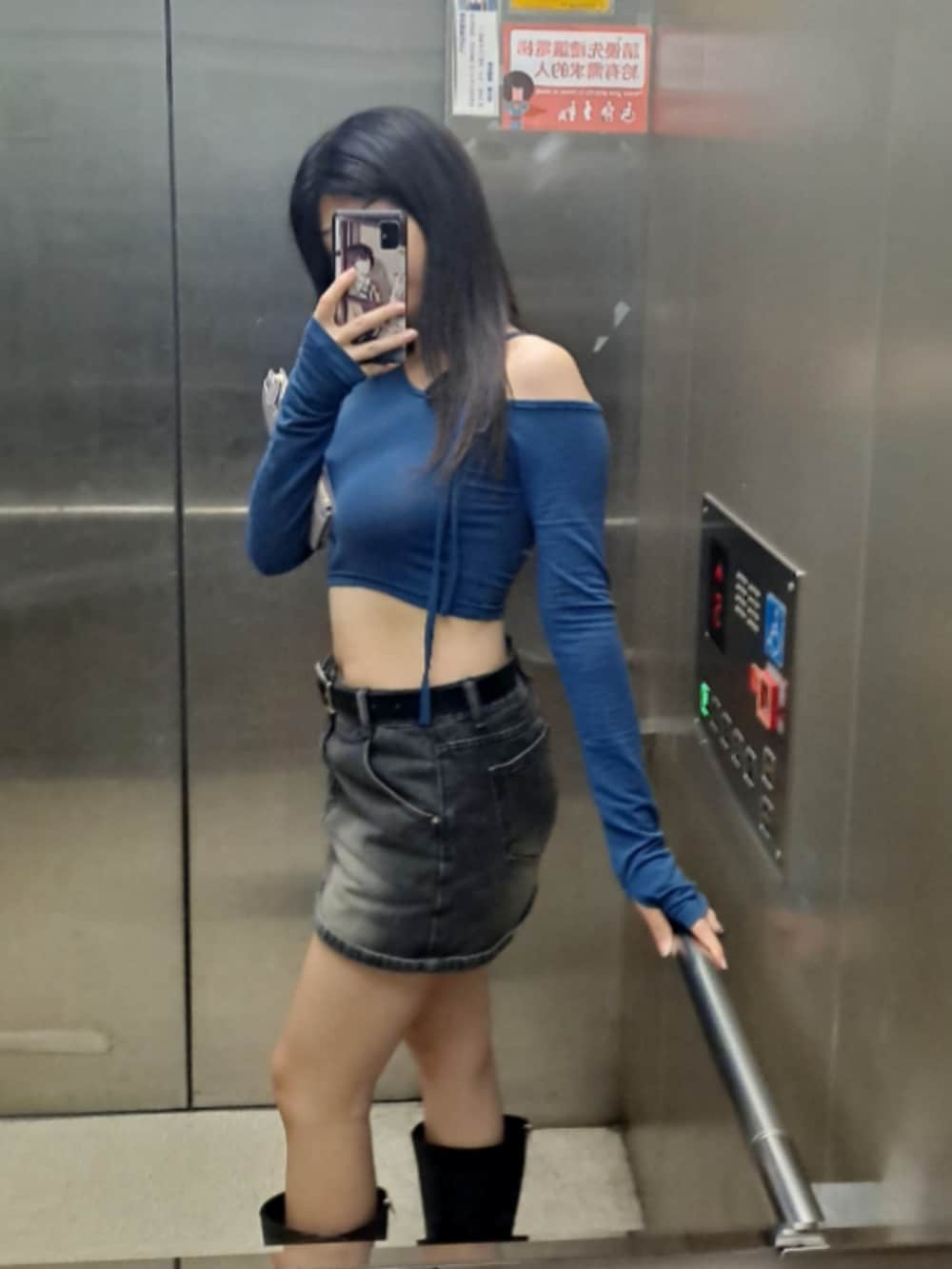 ブラック系のデニムスカート、ブルー系のその他トップスを着用したレディースの春コーディネートの2枚目の写真