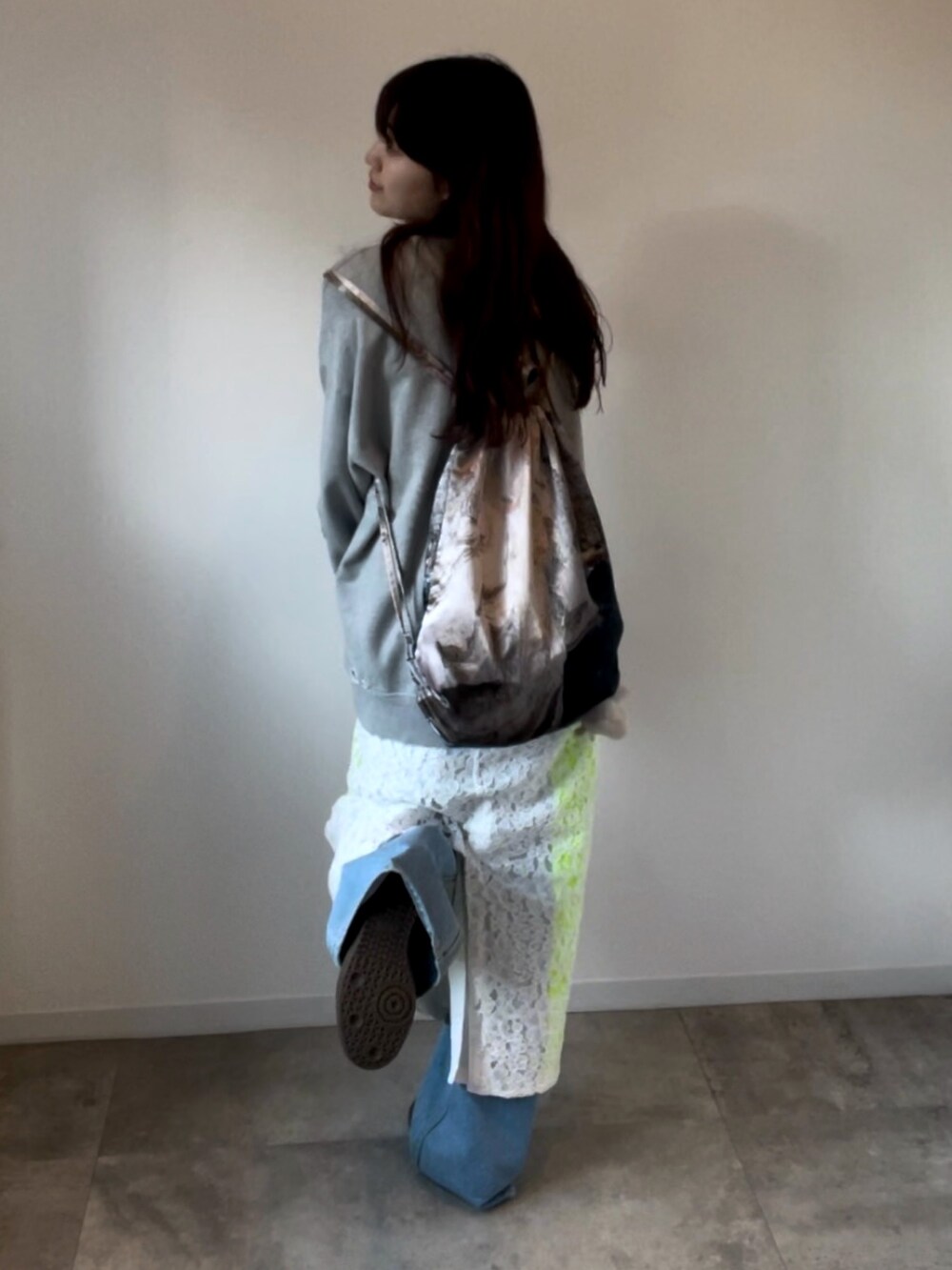 グレー系のスウェット、ホワイト系のスカートを着用したレディースの春コーディネートの2枚目の写真