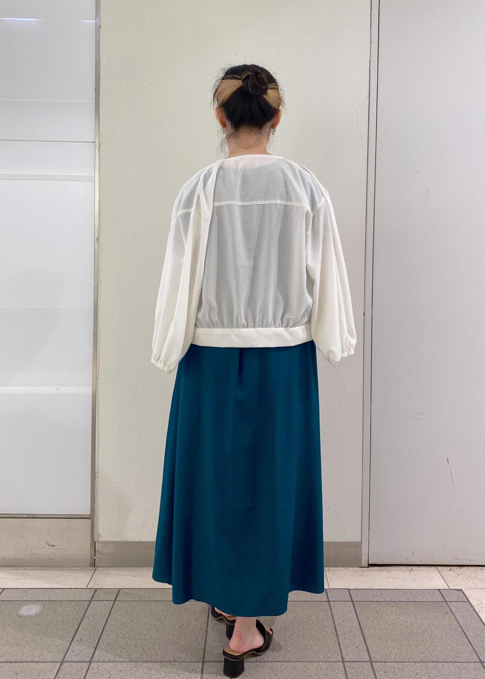 ブラック系のサンダル、ホワイト系のショルダーバッグ、グリーン系のワンピースを着用したレディースの夏コーディネートの4枚目の写真