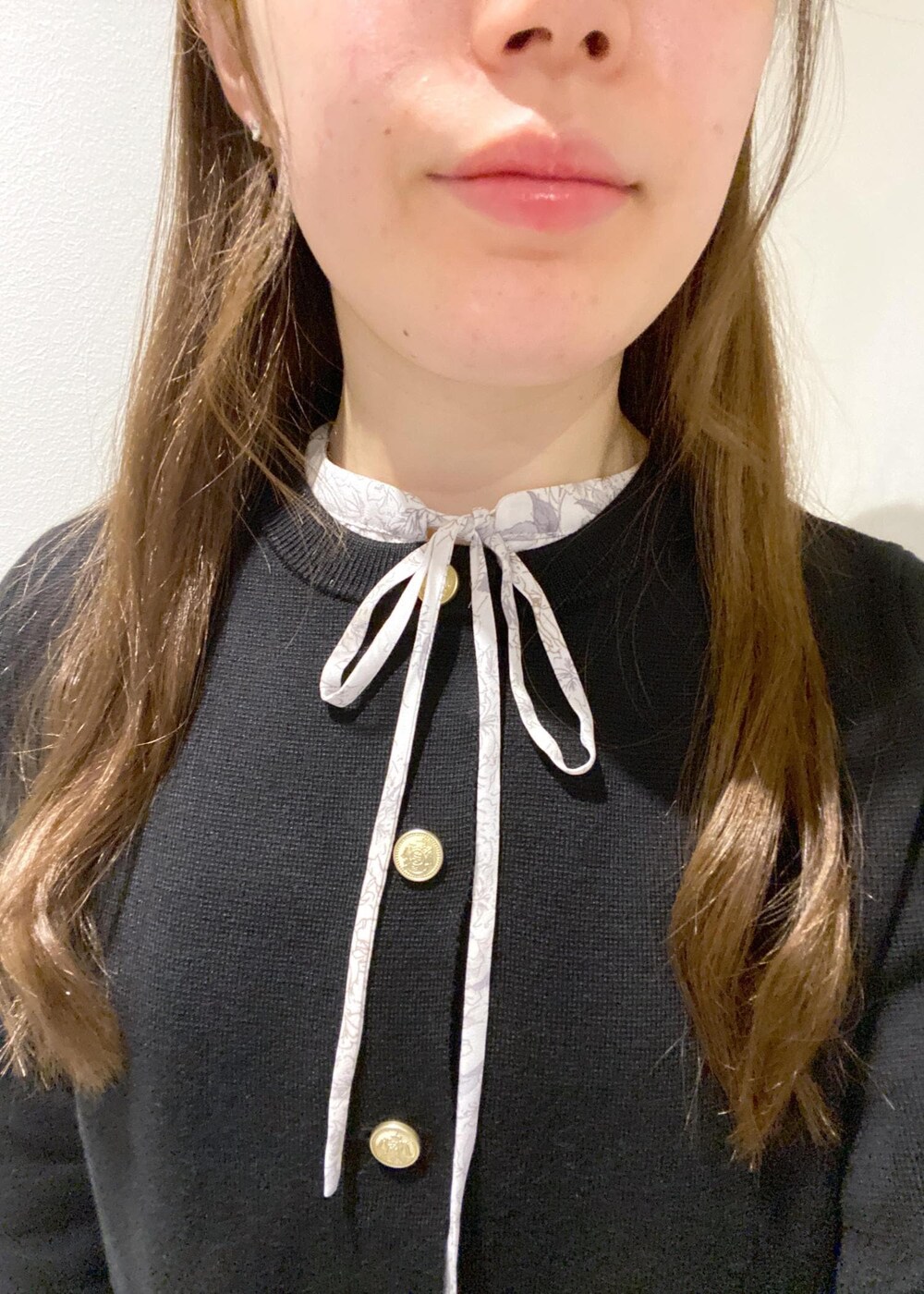 ホワイト系のワンピース、ブラック系のカーディガン/ボレロ、ブラック系のブーツを着用したレディースの冬コーディネートの8枚目の写真