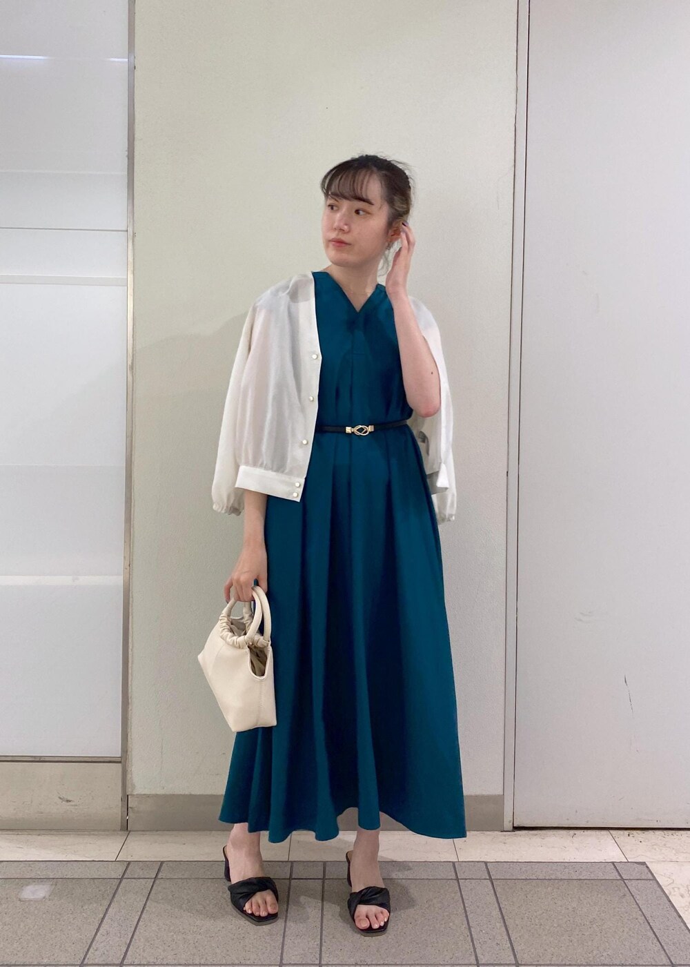 ブラック系のサンダル、ホワイト系のショルダーバッグ、グリーン系のワンピースを着用したレディースの夏コーディネートの2枚目の写真