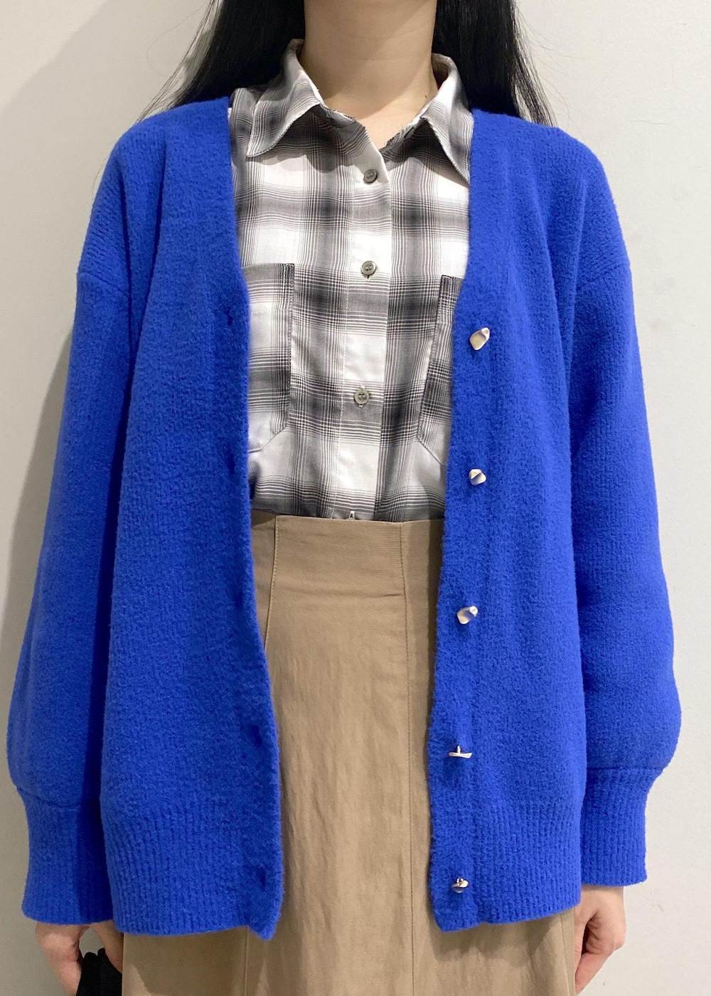 ベージュ系のスカート、ホワイト系のシャツ/ブラウス、ブルー系のカーディガン/ボレロを着用したレディースの秋コーディネートの5枚目の写真