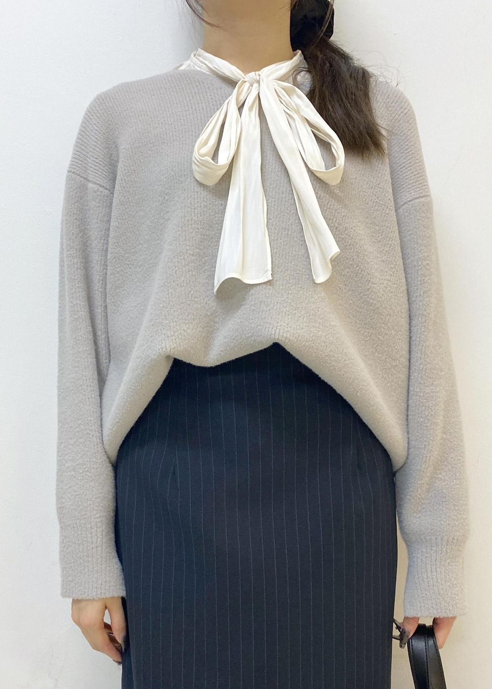 ブルー系のスカート、グレー系のニット/セーター、ホワイト系のシャツ/ブラウスを着用したレディースの秋コーディネートの5枚目の写真