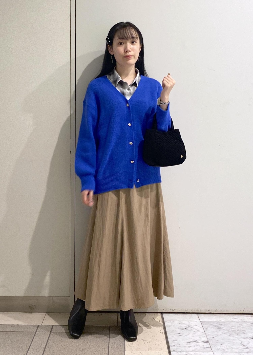 ベージュ系のスカート、ホワイト系のシャツ/ブラウス、ブルー系のカーディガン/ボレロを着用したレディースの秋コーディネートの2枚目の写真
