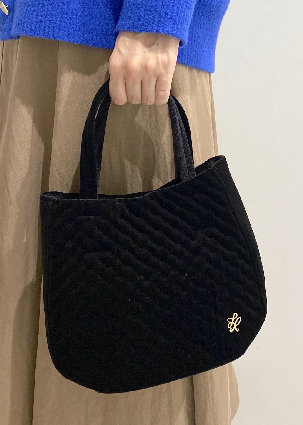 ベージュ系のスカート、ホワイト系のシャツ/ブラウス、ブルー系のカーディガン/ボレロを着用したレディースの秋コーディネートの7枚目の写真