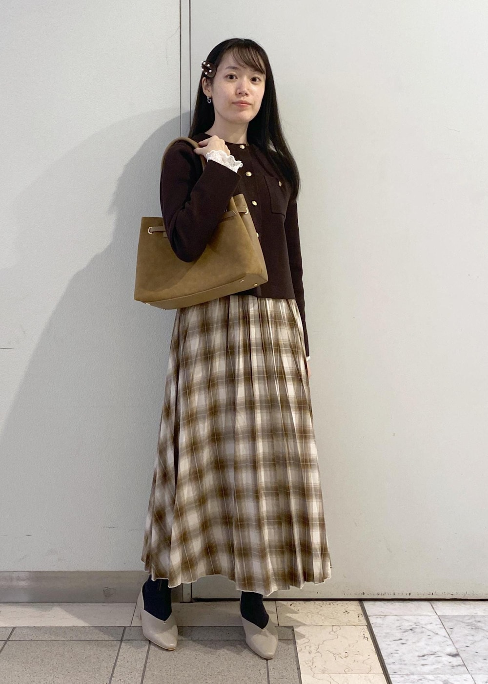 イエロー系のトートバッグ、イエロー系のスカート、ホワイト系のTシャツ/カットソーを着用したレディースの秋コーディネートの2枚目の写真