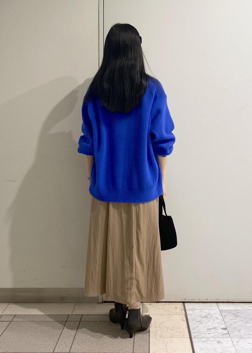 ベージュ系のスカート、ホワイト系のシャツ/ブラウス、ブルー系のカーディガン/ボレロを着用したレディースの秋コーディネートの4枚目の写真