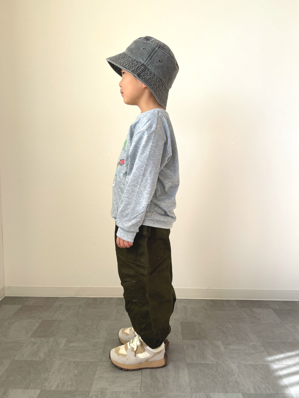 グレー系のスウェット、ホワイト系のスニーカー、ブラック系のハットを着用したキッズの冬コーディネートの2枚目の写真