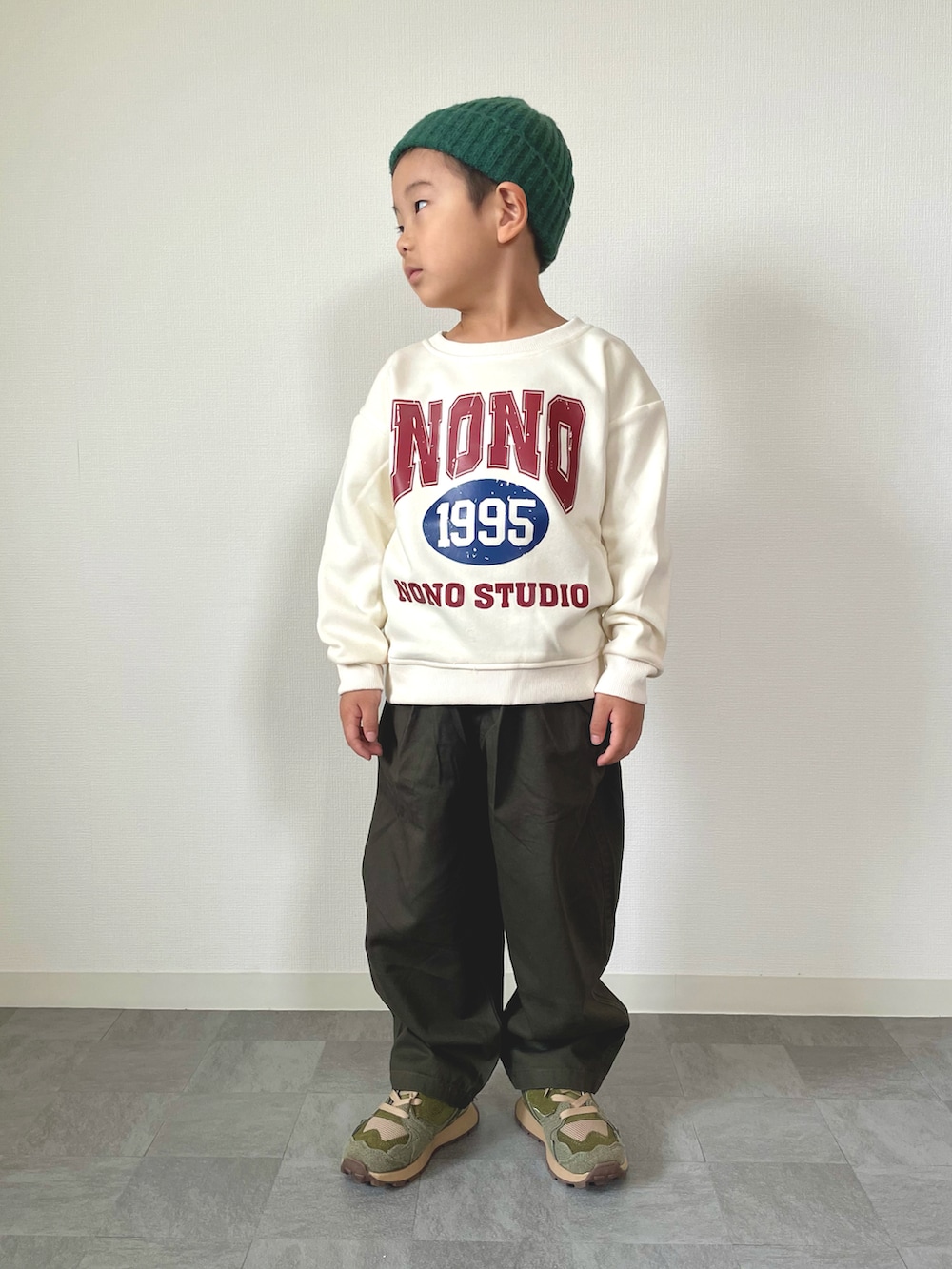 ホワイト系のスウェット、グレー系のチノパンツ、グリーン系のスニーカーを着用したキッズの秋コーディネートの4枚目の写真