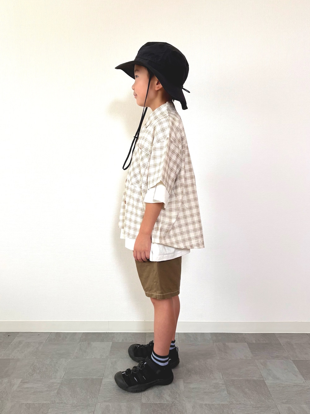 ホワイト系のTシャツ/カットソー、ブラウン系のその他パンツ、ブラック系のサンダルを着用したキッズの夏コーディネートの2枚目の写真