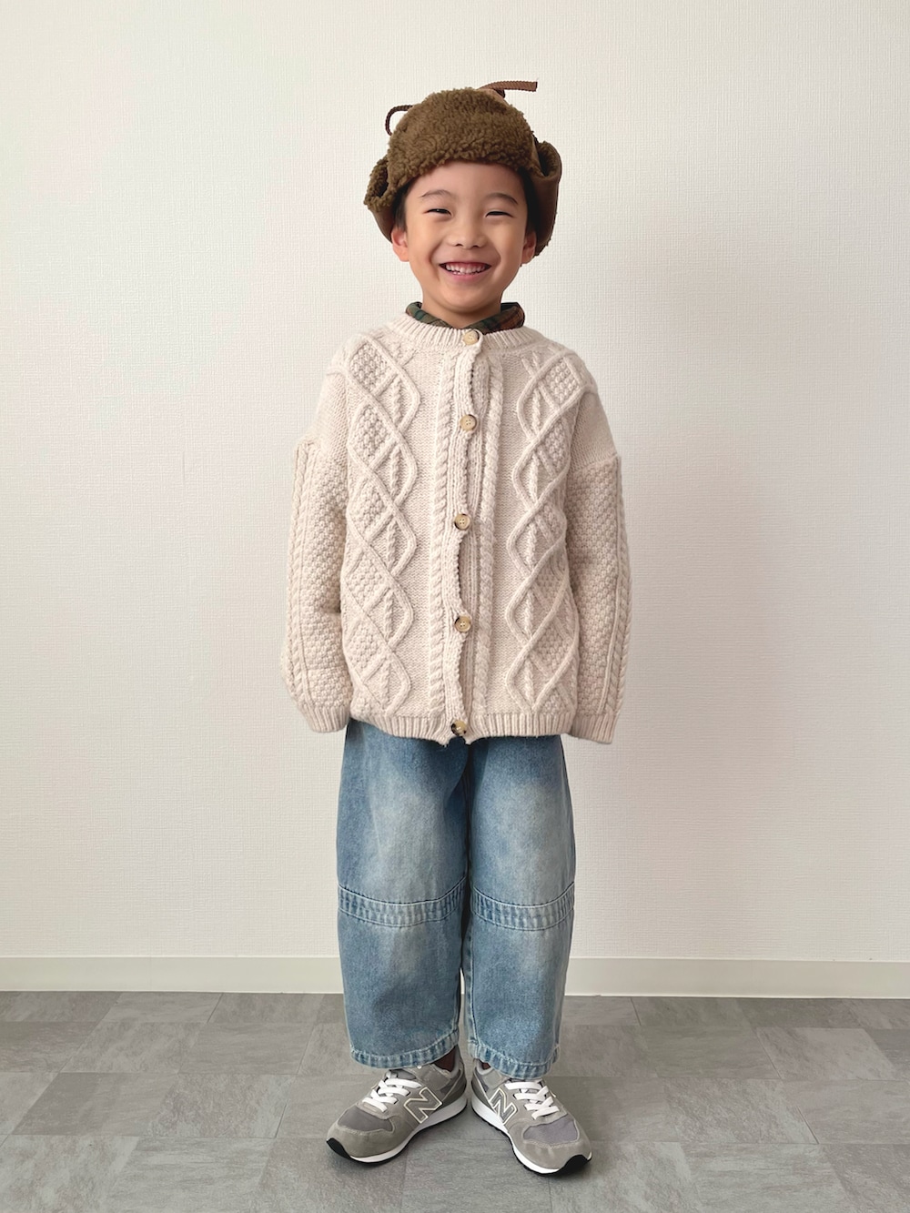 グリーン系のシャツ/ブラウス、ホワイト系のカーディガン/ボレロ、ブルー系のデニムパンツを着用したキッズの冬コーディネートの4枚目の写真