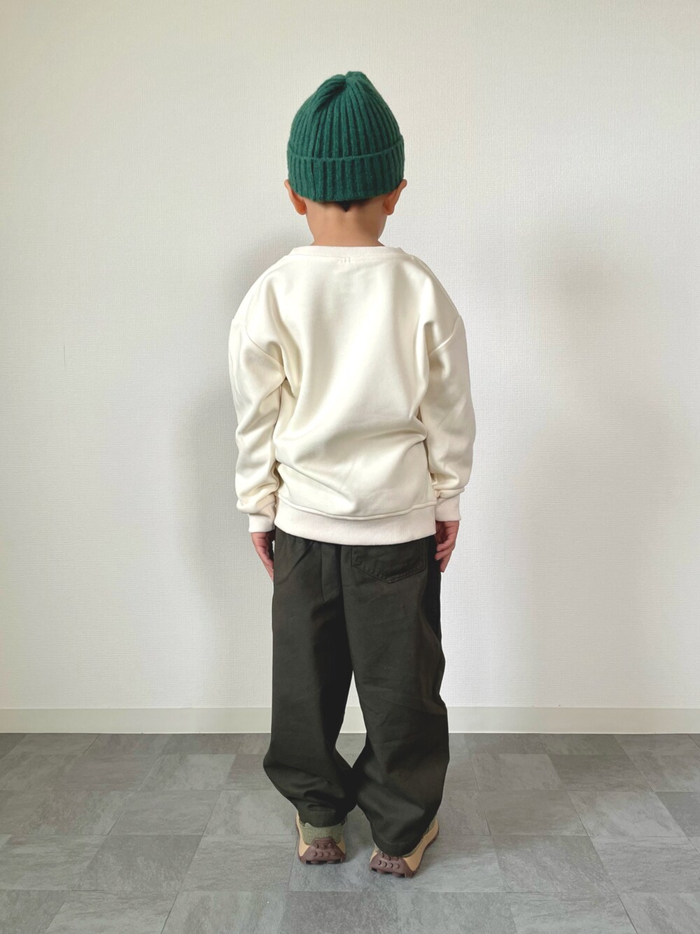 ホワイト系のスウェット、グレー系のチノパンツ、グリーン系のスニーカーを着用したキッズの秋コーディネートの3枚目の写真