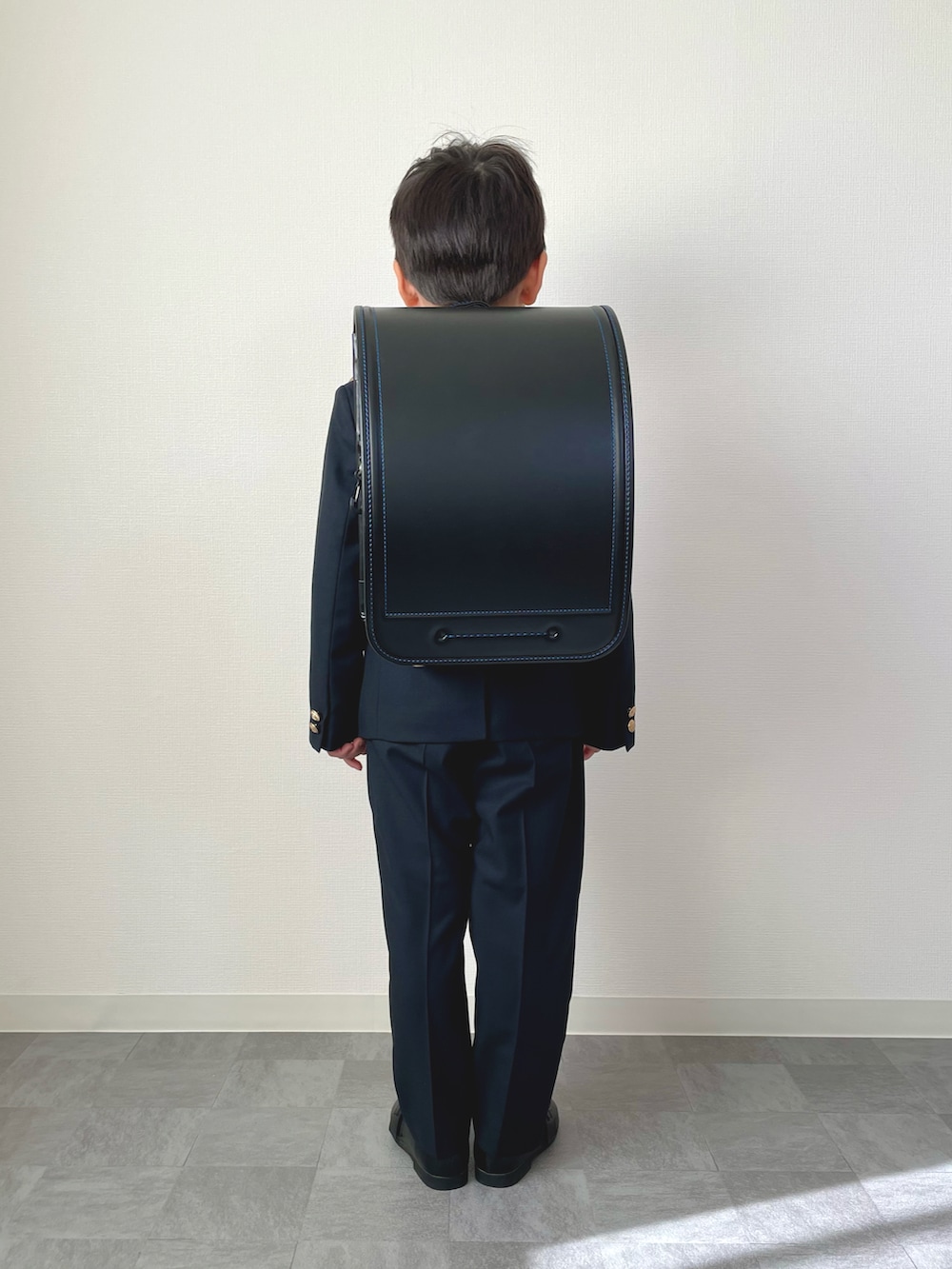 オレンジ系の蝶ネクタイ、ブルー系のシャツ/ブラウス、ブルー系のスーツジャケットを着用したキッズの春コーディネートの3枚目の写真