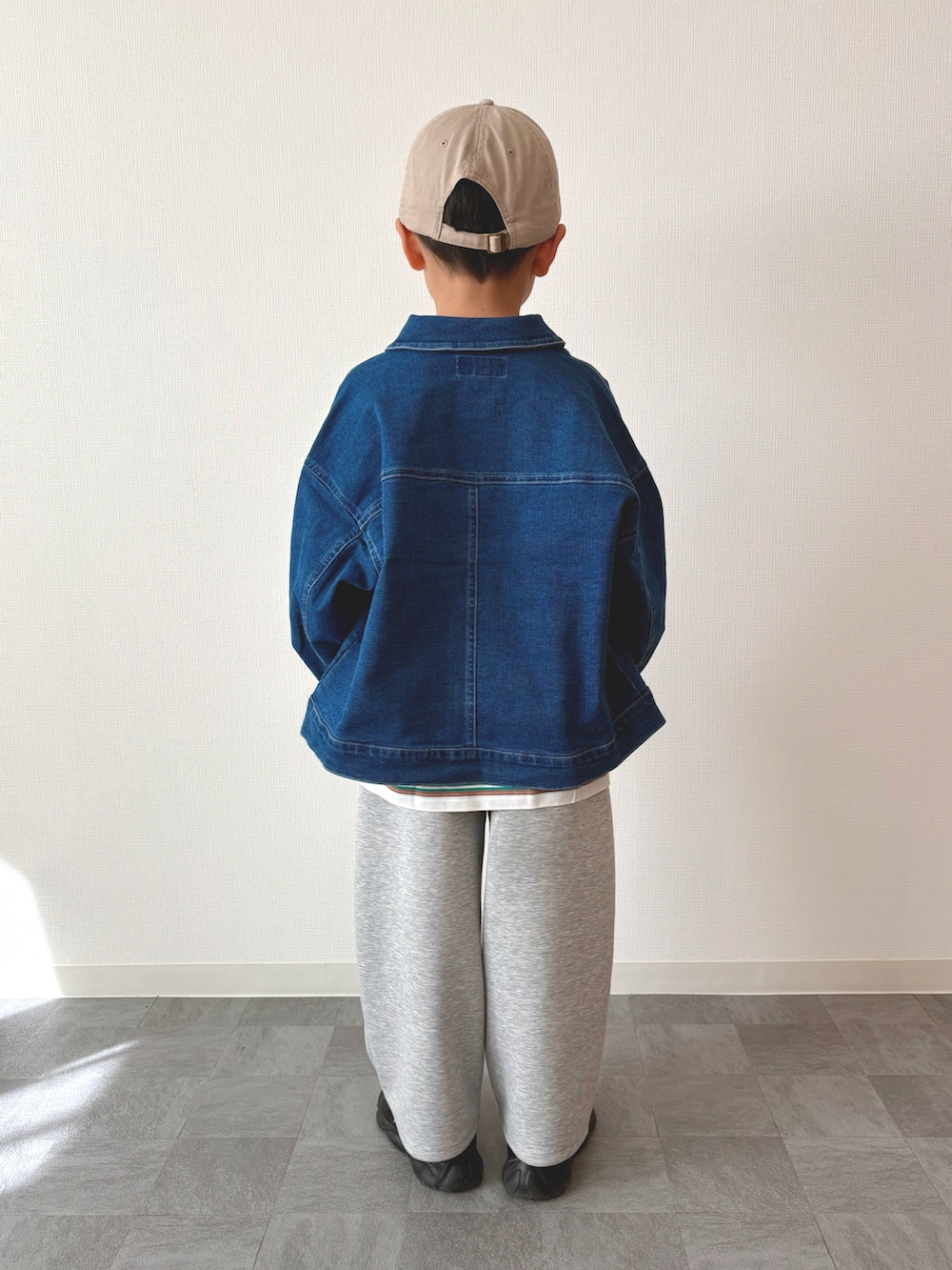 ブラック系のスニーカー、グリーン系のTシャツ/カットソー、ブルー系のデニムジャケットを着用したキッズの春コーディネートの3枚目の写真