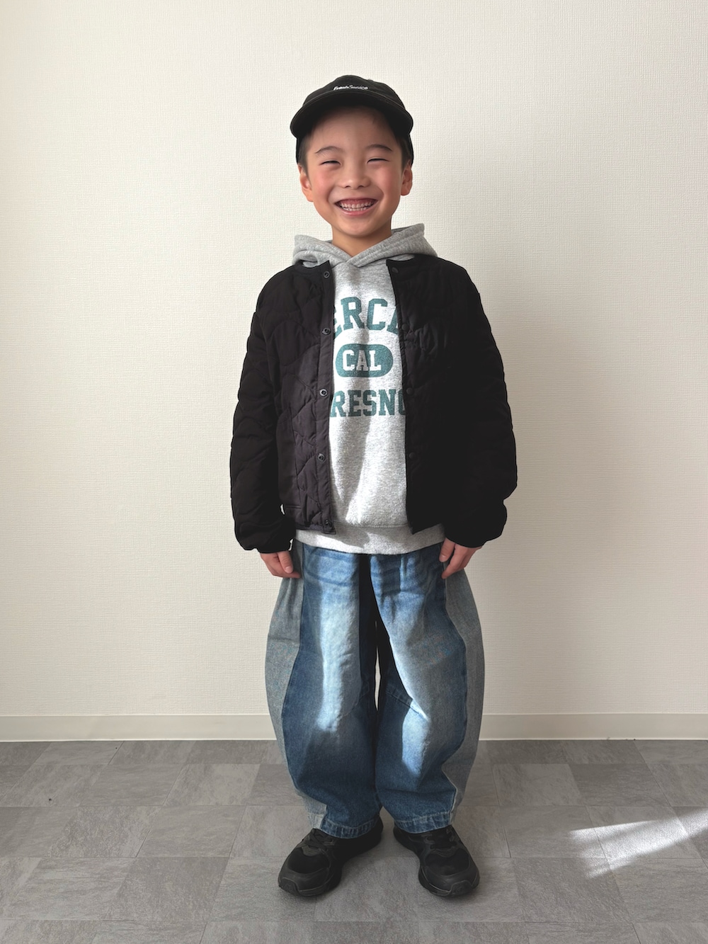 グレー系のパーカー、ブラック系のブルゾン、ブルー系のデニムパンツを着用したキッズの冬コーディネートの4枚目の写真