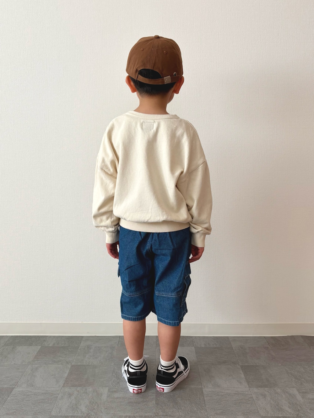 ブルー系のカーゴパンツ、ブラック系のスニーカー、ホワイト系のスウェットを着用したキッズの春コーディネートの3枚目の写真