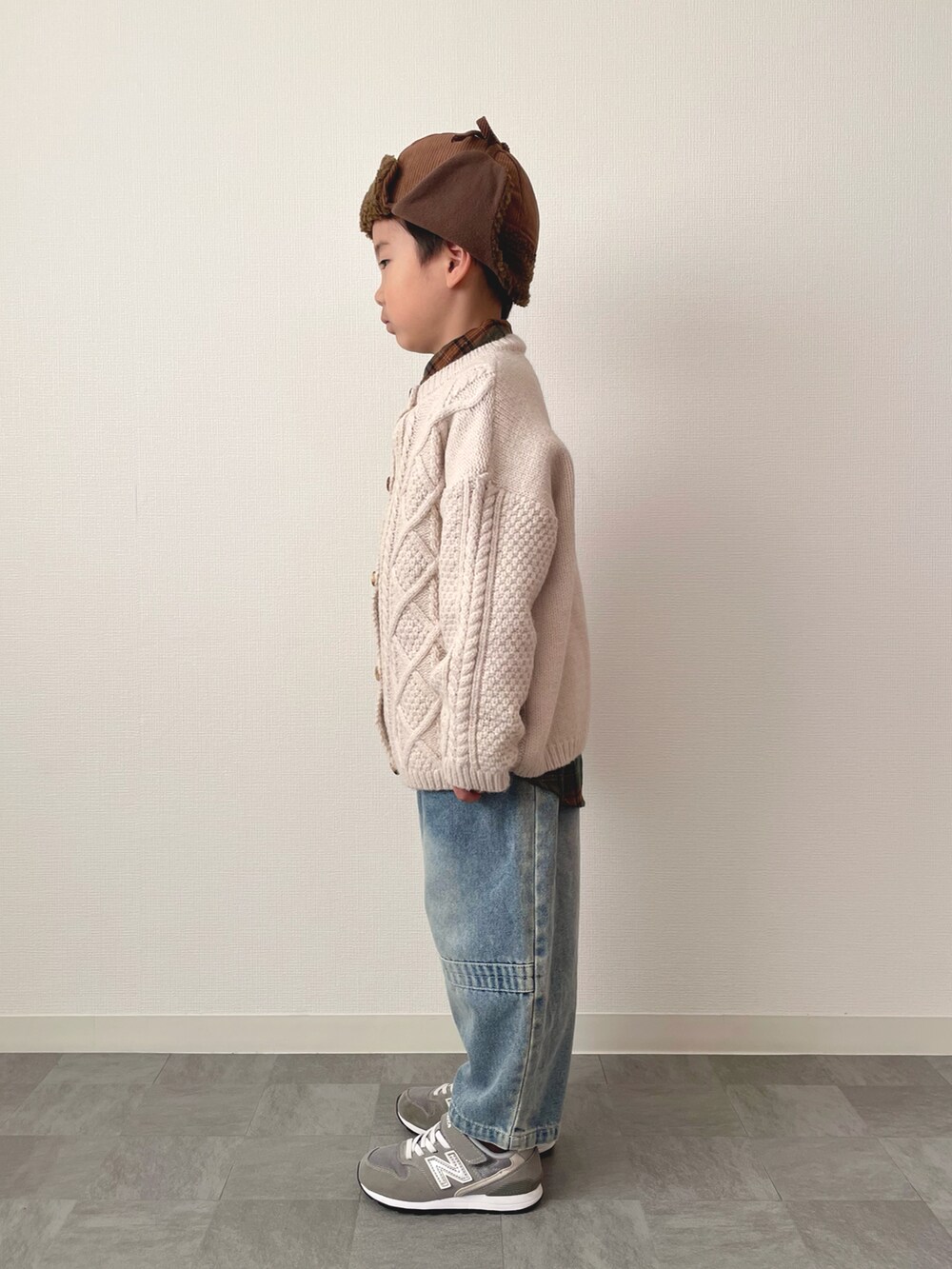 グリーン系のシャツ/ブラウス、ホワイト系のカーディガン/ボレロ、ブルー系のデニムパンツを着用したキッズの冬コーディネートの2枚目の写真