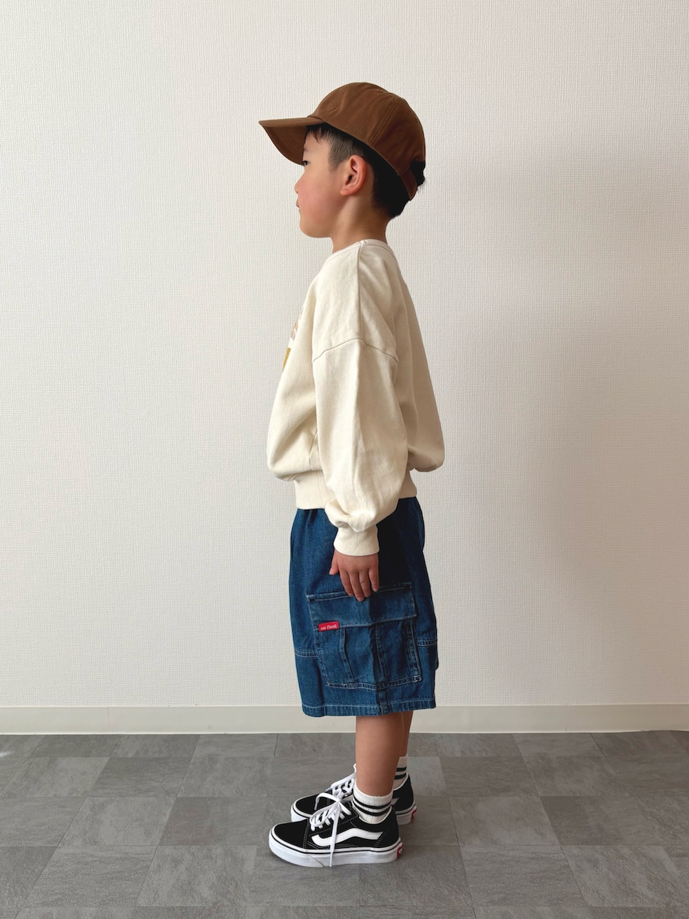 ブルー系のカーゴパンツ、ブラック系のスニーカー、ホワイト系のスウェットを着用したキッズの春コーディネートの2枚目の写真