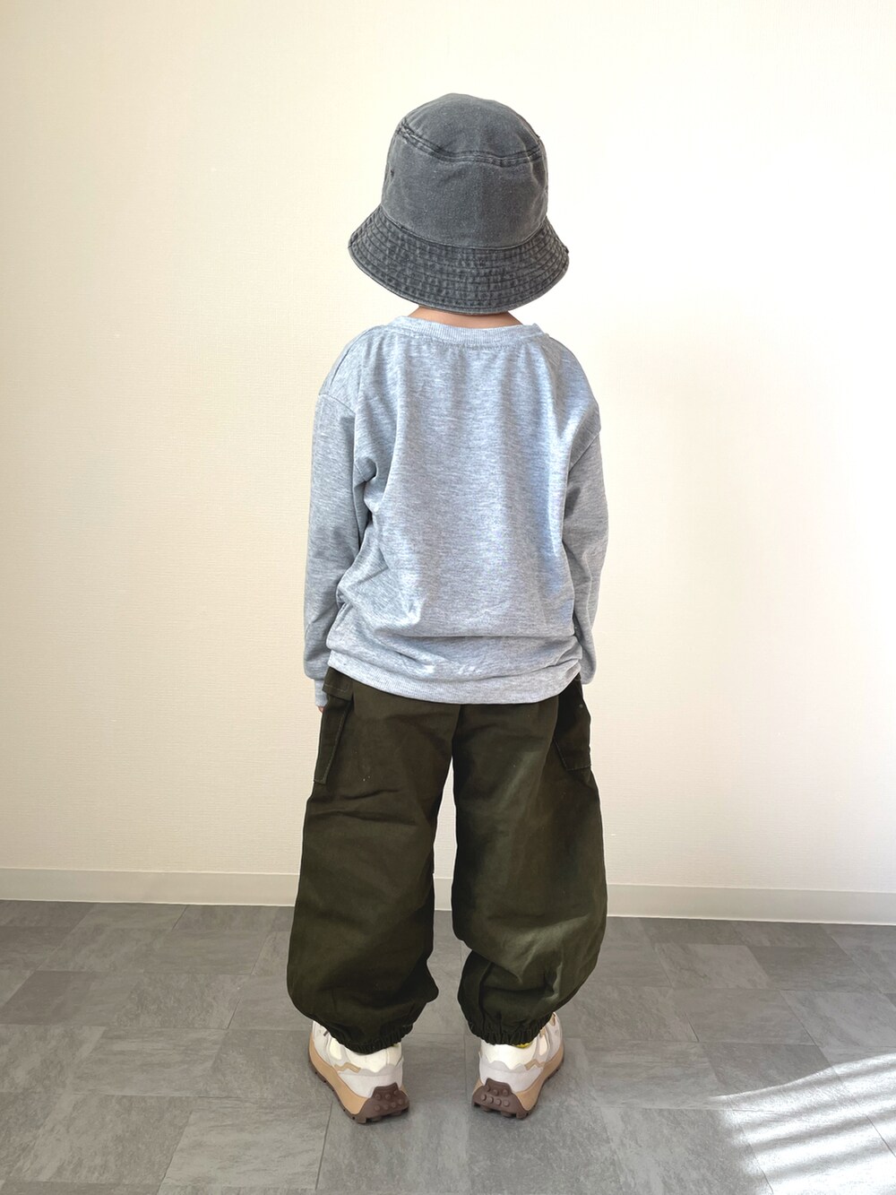 グレー系のスウェット、ホワイト系のスニーカー、ブラック系のハットを着用したキッズの冬コーディネートの3枚目の写真