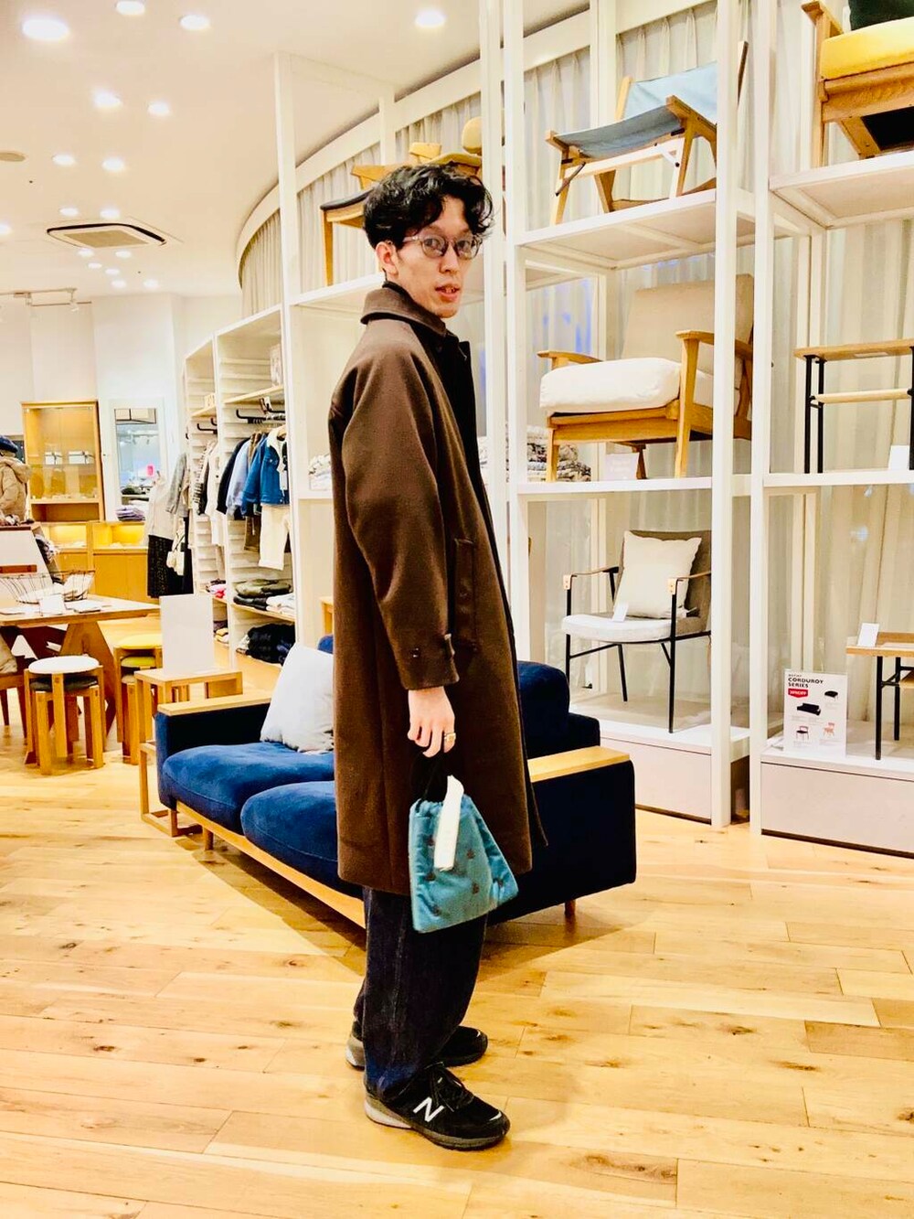 ブルー系のショルダーバッグ、ブラウン系のステンカラーコートを着用したメンズの冬コーディネートの3枚目の写真