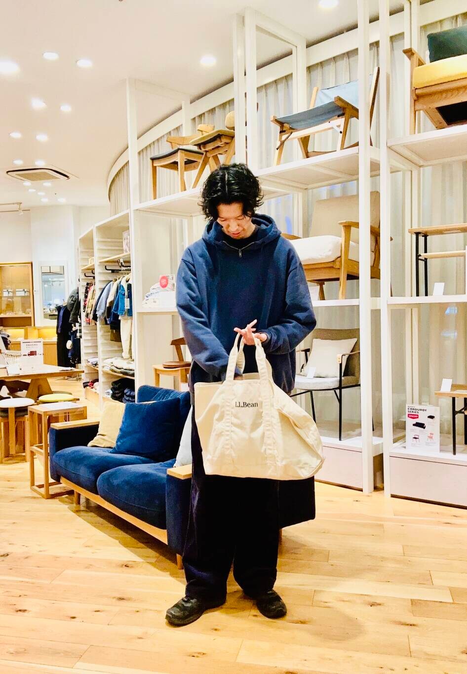 ホワイト系のトートバッグ、ブルー系のパーカーを着用したメンズの冬コーディネートの2枚目の写真