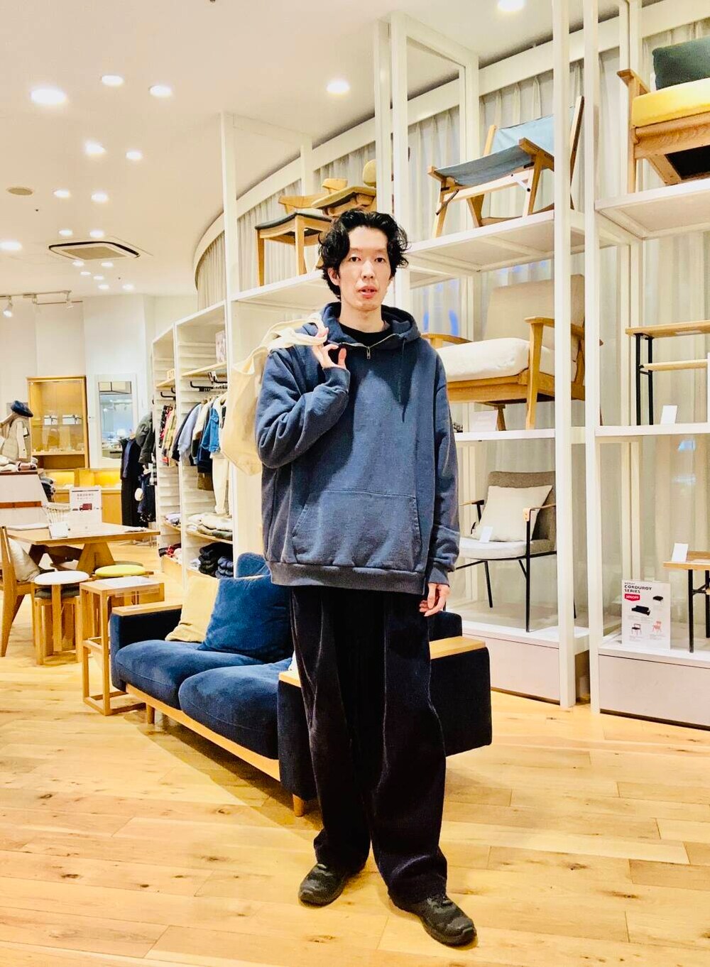 ホワイト系のトートバッグ、ブルー系のパーカーを着用したメンズの冬コーディネートの3枚目の写真