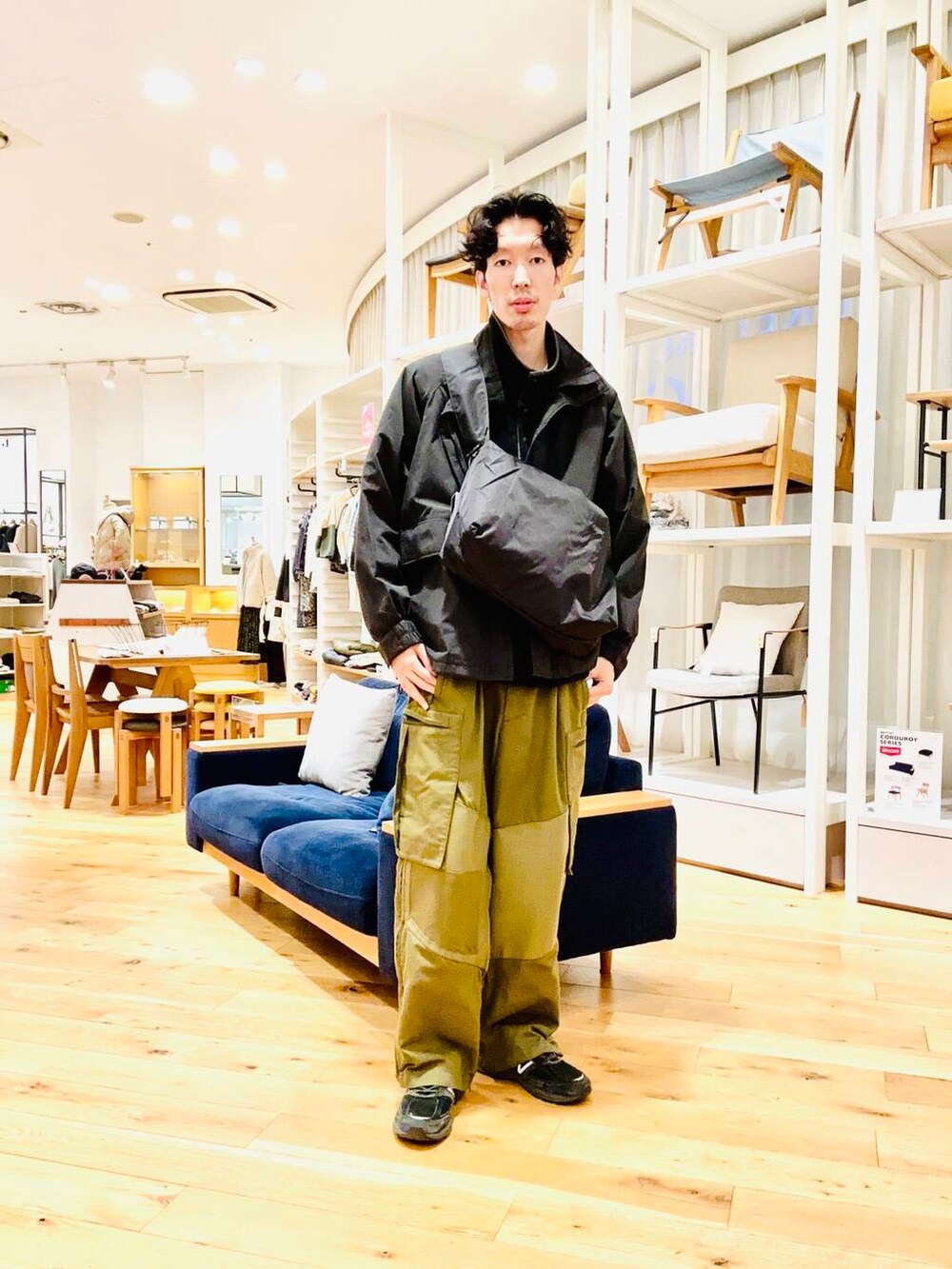 グレー系のショルダーバッグ、ブラック系のブルゾンを着用したメンズの冬コーディネートの2枚目の写真