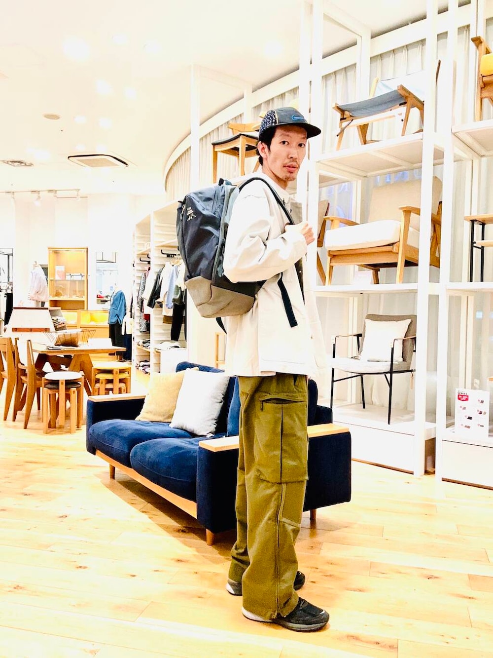 ブルー系のバックパック/リュック、ベージュ系のカバーオールを着用したメンズの冬コーディネートの2枚目の写真