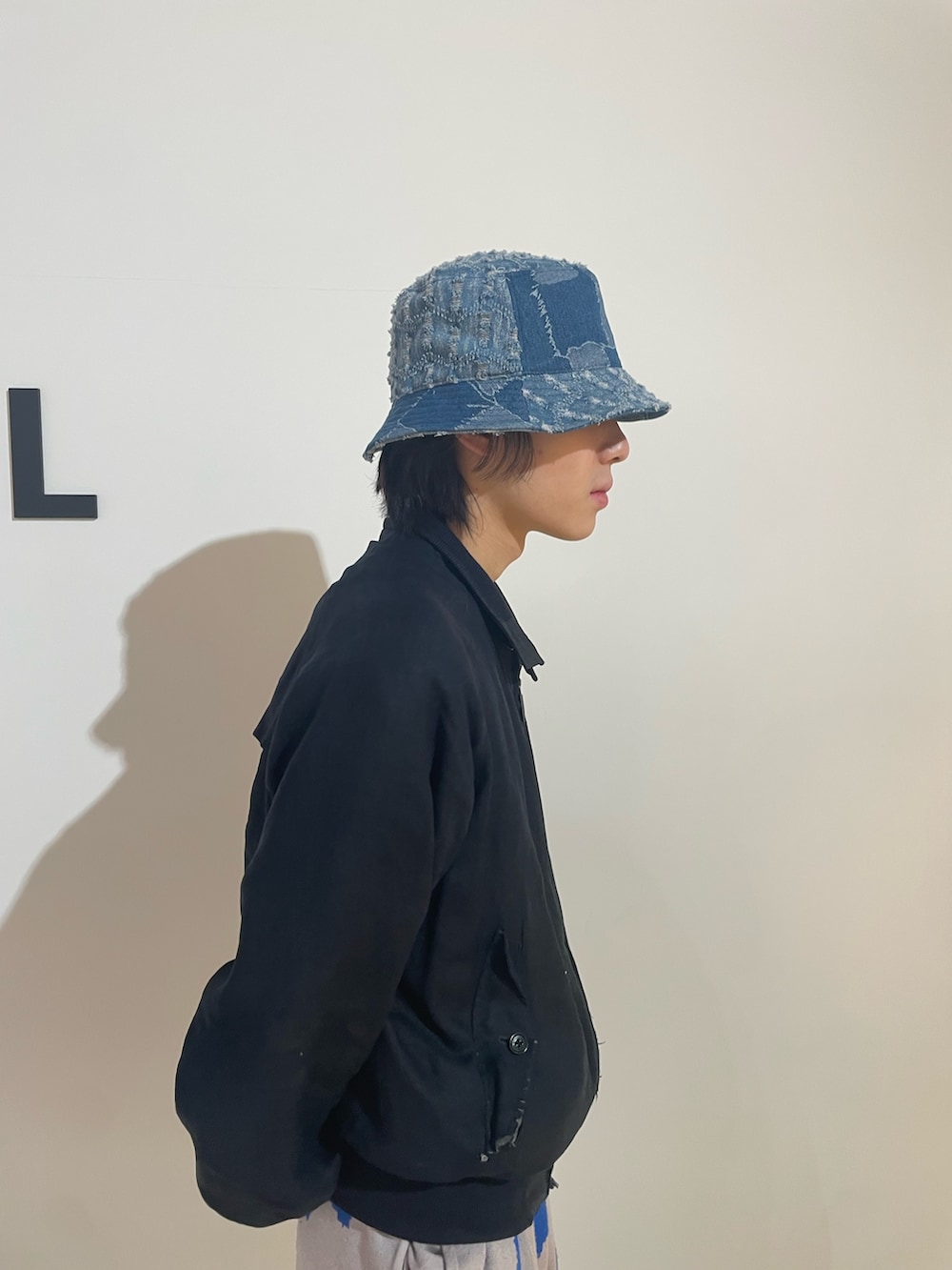 グレー系のスウェットパンツ、ブルー系のハットを着用したメンズの春コーディネートの2枚目の写真